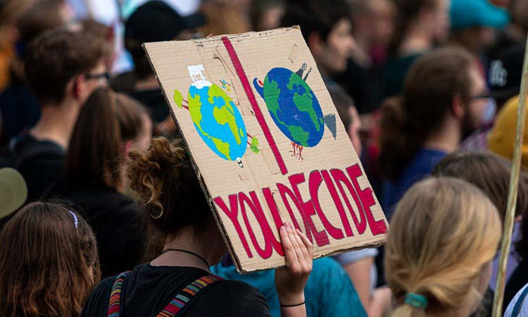 A young person holding up a sign during an environmental demonstration