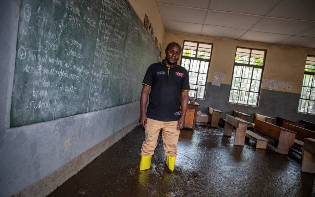 Patient Kyahi, Principal of Sake Elementary School in front of the blackboard in his mud-filled classroom. Photo Credit sibylle desjardins_Climate Visuals Countdown