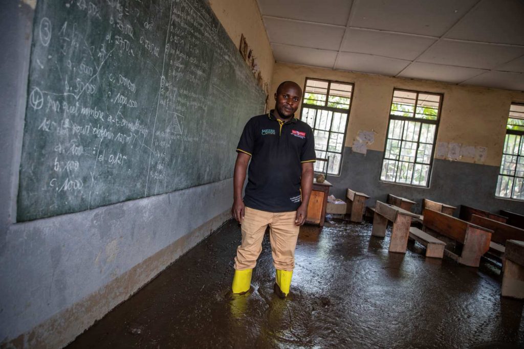 Patient Kyahi, Principal of Sake Elementary School in front of the blackboard in his mud-filled classroom. Photo Credit sibylle desjardins_Climate Visuals Countdown